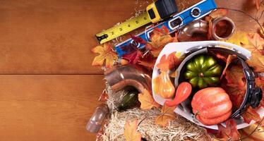 Happy Thanksgiving with construction tools, maple leaves and pumpkin on wood background. Autumn composition with copy space photo