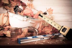 Thanksgiving with construction tools, maple leaves and pumpkin on wood background. Autumn composition with copy space. photo