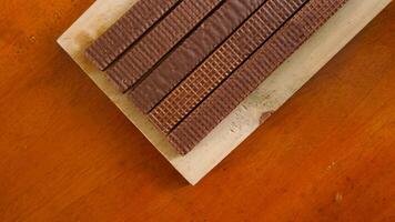 Top view of chocolate wafer sticks on a wooden board isolated on wooden textured background photo