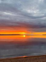 A mesmerizing sunset sets fiery whispers across a tranquil lake, evoking serene introspection on Sukkot and Earth Day photo