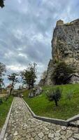 Ancient fortress perched on towering rock under brooding skies, perfect for National Fortress Day and Pathfinders Mythic Journey photo