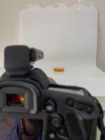 Lens poised like a vigilant eye, capturing a solitary coin, evoking Plutus silent wealth, perfect for World Thrift Day photo