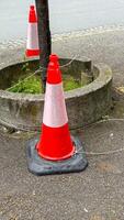 Orange traffic cone guards whispers of urban ecology, reminiscent of Tinkering Day, solitude in the bustling cityscape photo
