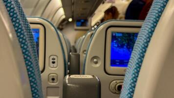 In flight entertainment screens glow softly on a bustling passenger aircraft, evoking Digital Detox Day and Trans Siberian Odyssey dreams photo