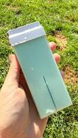 A Caucasian hand holds a pastel sea foam green soap bar, perfect for Earth Day or Hygge inspired minimalist rituals photo