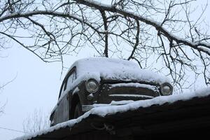 The car is in the snow on the roof of the house. monument in the snow photo