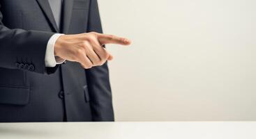 A businessman is pointing his finger towards the right side photo