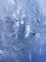 Dramatic Clouds Interwoven with Cables Form an Artistic Contrast Against a Clear Blue Sky photo