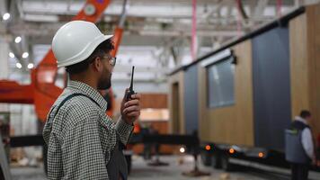 Construction worker communicating with walkie talkie in factory video
