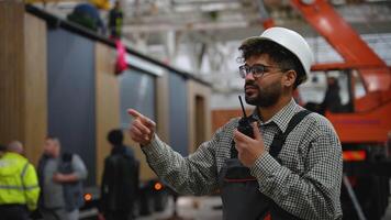 Construction site manager giving instructions with walkie talkie video