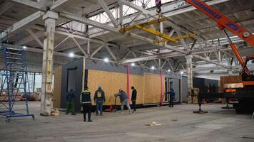 Construction workers moving prefabricated modular house in factory. Ternopil, Ukraine - 1 February 2025 video