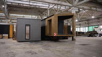 Prefabricated tiny houses moving on a platform trailer inside a large industrial building video