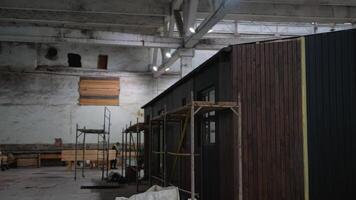 Workers building a tiny home in a warehouse video
