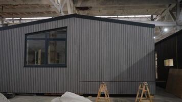 Modular house under construction in a large warehouse video