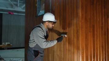 Professional painter applying varnish on wooden wall video