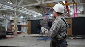 Engineer coordinating lifting operations in spacious industrial facility video