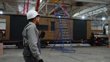 Construction worker communicating with walkie talkie in factory video