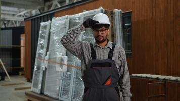 Construction worker adjusting hardhat in warehouse video