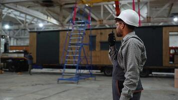 Construction worker communicating and pointing in factory video