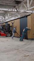 Workers pushing prefabricated tiny house with pallet jack in factory. Ternopil, Ukraine - 1 February 2025 video