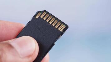 Hand holding a memory card against a light background video