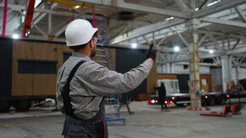 Engineer supervising prefabricated house transportation in factory video