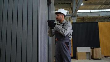 Construction worker using cordless screwdriver on prefabricated building video