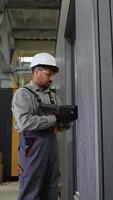 Construction worker using cordless screwdriver in factory video