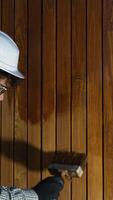 Construction worker applying varnish on a wooden surface video