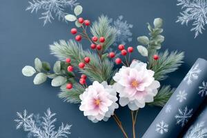 Christmas bouquet with pink peonies, red berries, pine branches and wrapping paper lying on dark blue background photo