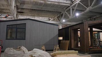 Professional carpenter building modern tiny house in large workshop video