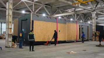 Factory workers moving prefabricated modular building using pallet jack. Ternopil, Ukraine - 1 February 2025 video