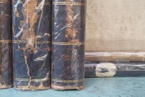 Old leather-bound books stacked on a wooden table photo