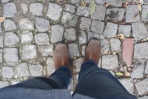 Walking on cobblestones while wearing brown boots photo