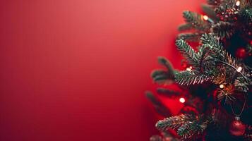 Christmas tree branch with ornaments and lights on red background photo