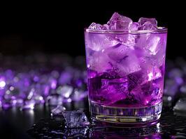 vibrant purple drink with ice cubes in glass placed on reflective surface with glowing background photo