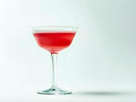 Elegant red cocktail in clear glass against minimal white background photo