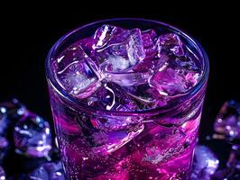 Close up of a refreshing purple cocktail with ice cubes in glass on black background photo