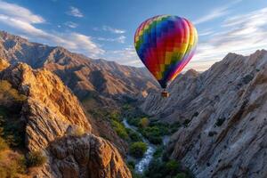 Hot air balloon soaring over rocky mountains during a vibrant su photo