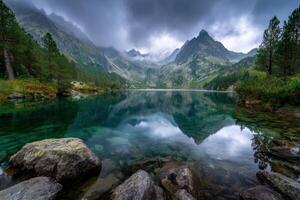 Mountain lake reflects peaks and clouds in a serene landscape ca photo