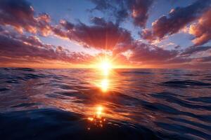 Sunset over calm ocean waters with vibrant clouds reflecting warm colors photo