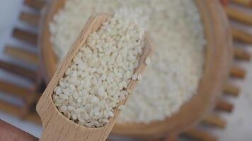 Sesame seeds displayed in wooden scoop for culinary use video