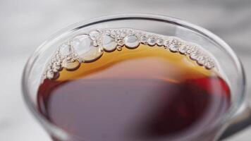 Coffee drink with bubbles in glass on a smooth surface video