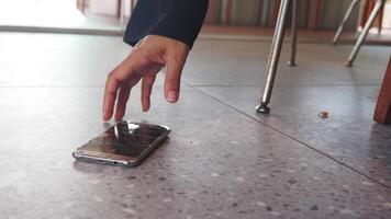 Phone dropped on floor in cafe setting during daytime video