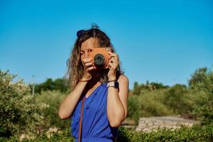 Woman taking photo with instant camera on sunny day