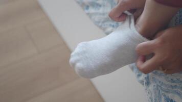 Putting on a sock carefully during a morning routine video