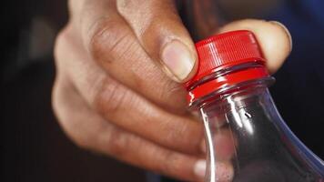 Opening a bottle with a red cap in a casual setting video