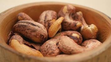 Exploring the rich texture of roasted cashew nuts in a wooden bowl video
