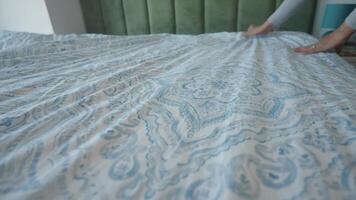 Making a bed with patterned sheets in a cozy bedroom video