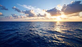 Dramatic sunset over a calm blue ocean. Sun setting on the horizon with clouds, reflecting on the sea. Peaceful seascape background for travel, meditation, or nature concepts. photo